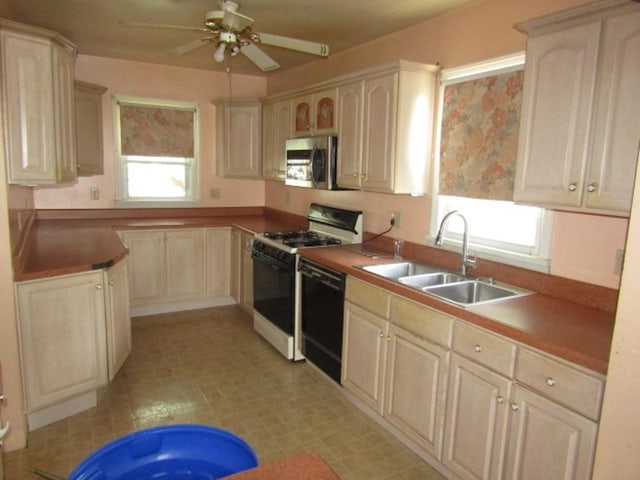 2445 Brownsville Rd, Carrick, PA 15210 - kitchen featuring stainless steel microwave, black dishwasher, a sink, gas range oven, and ceiling fan