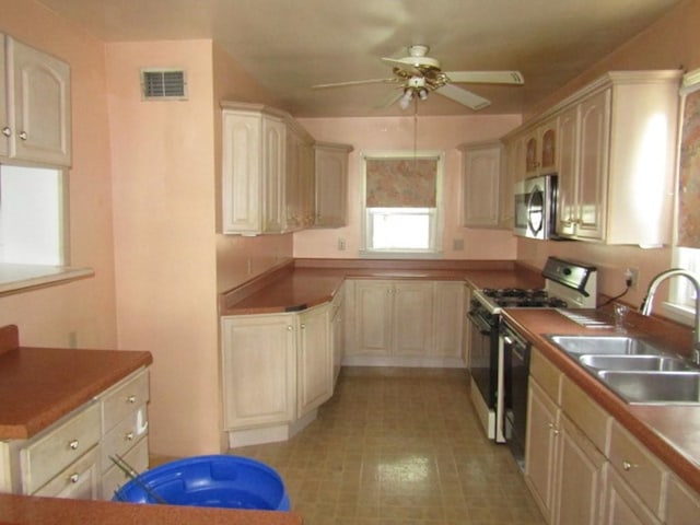 2445 Brownsville Rd, Carrick, PA 15210 - kitchen with range with gas cooktop, a sink, ceiling fan, stainless steel microwave, and black dishwasher