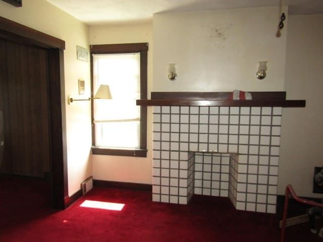 2445 Brownsville Rd, Carrick, PA 15210 - unfurnished living room with dark carpet and baseboards