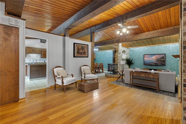 1369 Old Pulaski Rd, Neshannock Twp, PA 16105 - living area with a wood stove, light wood-style flooring, wooden ceiling with exposed beams, and ceiling fan