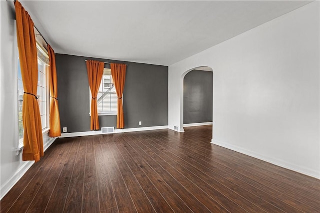 512 Pine Ave, Ellwood City Law, PA 16117 - empty room with arched walkways, baseboards, and dark wood-type flooring
