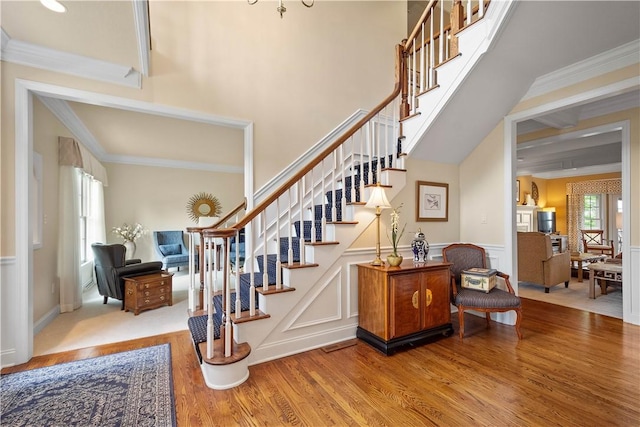 409 Foxwood Ln, Scott Twp Sal, PA 15220 - stairway featuring healthy amount of natural light, wood finished floors, crown molding, wainscoting, and a decorative wall