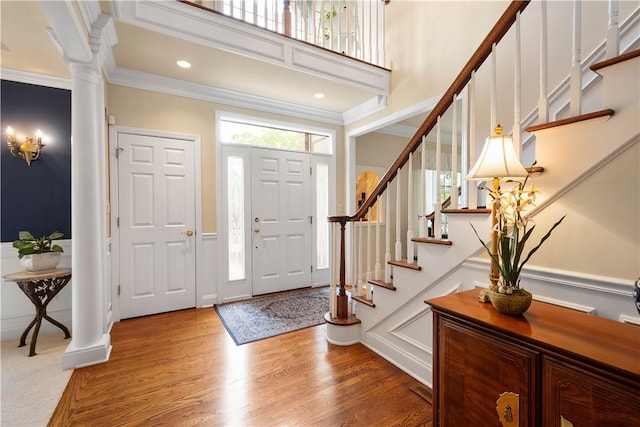409 Foxwood Ln, Scott Twp Sal, PA 15220 - entryway with decorative columns, ornamental molding, stairway, light wood finished floors, and a towering ceiling
