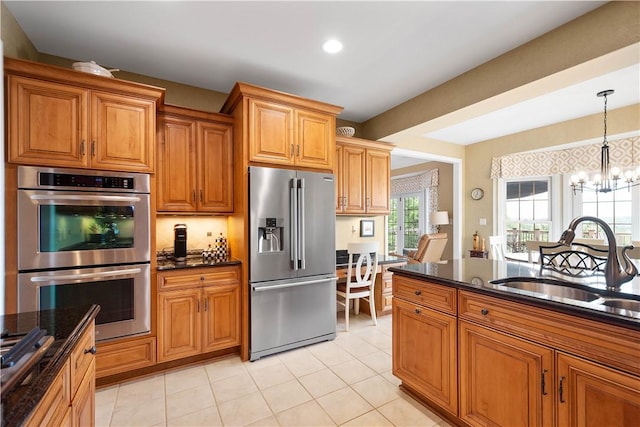 409 Foxwood Ln, Scott Twp Sal, PA 15220 - kitchen featuring stainless steel appliances, a sink, a chandelier, brown cabinetry, and hanging light fixtures