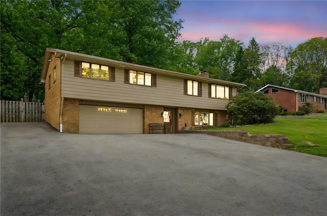 124 Hilton Rd, Unity Twp, PA 15601 - view of front of home featuring brick siding, a garage, driveway, a chimney, and view of scattered trees