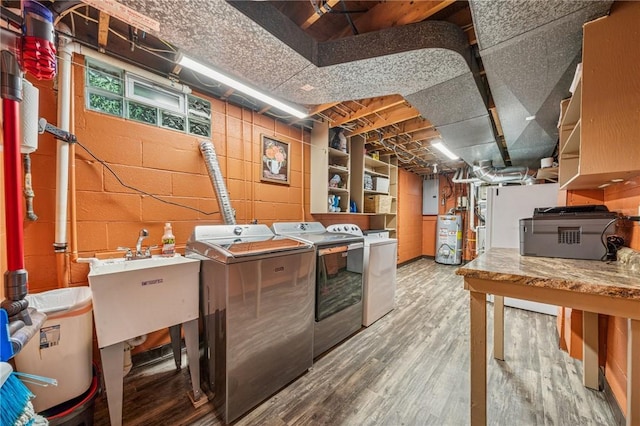 124 Hilton Rd, Unity Twp, PA 15601 - basement with gas water heater, washing machine and clothes dryer, electric panel, wood finished floors, and a sink