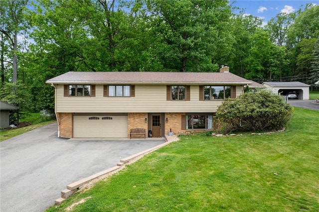 124 Hilton Rd, Unity Twp, PA 15601 - view of front of house with driveway, a front lawn, an attached garage, and brick siding