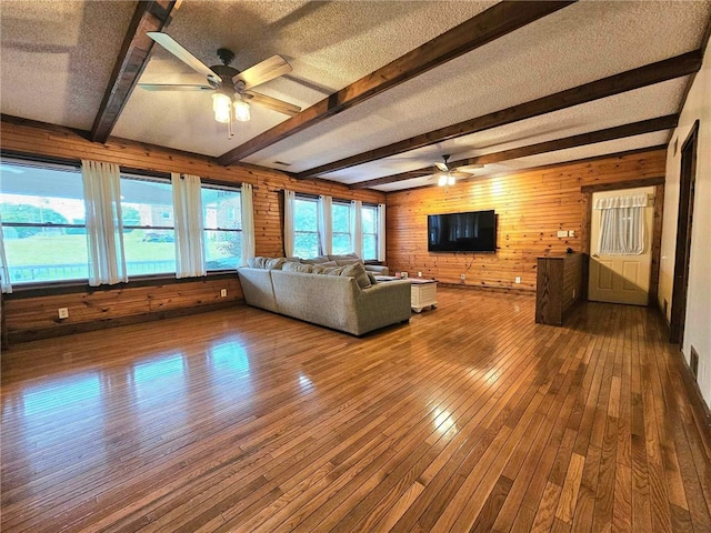 356 Reserve Sq, Wayne Twp Law, PA 16157 - unfurnished living room featuring a ceiling fan, wood walls, hardwood / wood-style flooring, beamed ceiling, and a textured ceiling