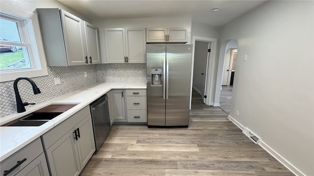 14 Haywood St, Carroll Twp, PA 15063 - kitchen with stainless steel appliances, a sink, gray cabinets, arched walkways, and backsplash