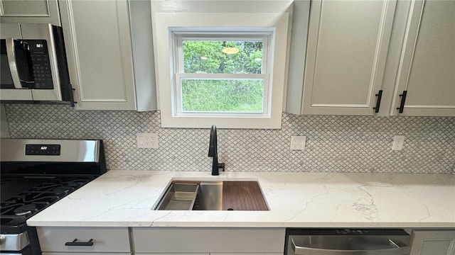 14 Haywood St, Carroll Twp, PA 15063 - kitchen featuring appliances with stainless steel finishes, a sink, tasteful backsplash, gray cabinetry, and light stone countertops