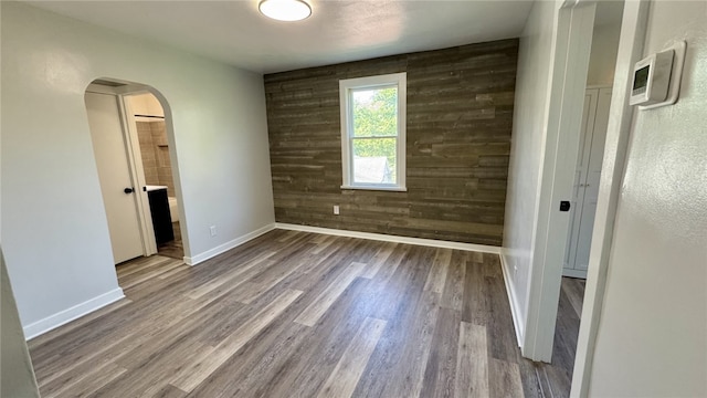 14 Haywood St, Carroll Twp, PA 15063 - empty room with arched walkways, wood finished floors, and baseboards