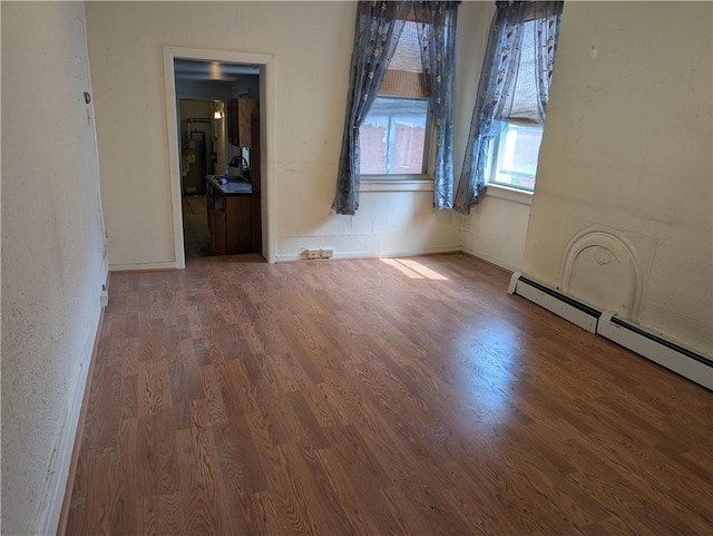 1321-1323 Bingham St, South Side, PA 15203 - empty room featuring wood finished floors, a baseboard radiator, and baseboards