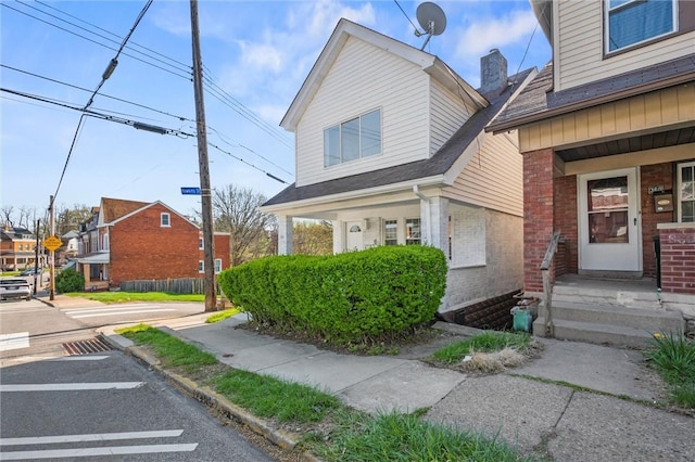 362 Marshall Ave, Observatory Hill, PA 15214 - view of front of property with brick siding, a chimney, a shingled roof, a porch, and uncovered parking