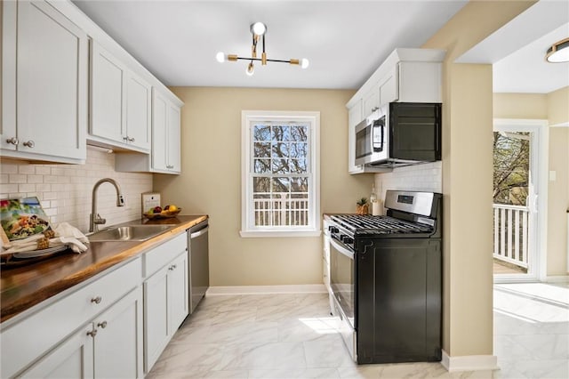 362 Marshall Ave, Observatory Hill, PA 15214 - kitchen featuring stainless steel appliances, a sink, light marble finish flooring, baseboards, and a chandelier