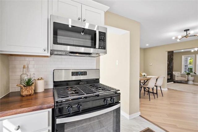 362 Marshall Ave, Observatory Hill, PA 15214 - kitchen featuring stainless steel appliances, wood counters, a chandelier, backsplash, and white cabinets