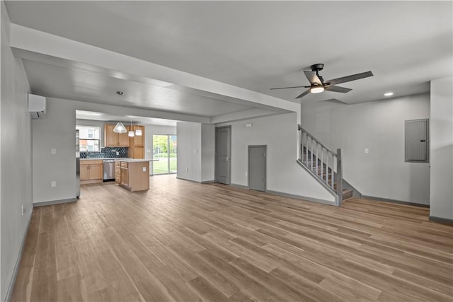 22 Mayflower St, Lincoln-Larimer, PA 15206 - unfurnished living room with a wall mounted air conditioner, light wood-style floors, electric panel, stairs, and ceiling fan