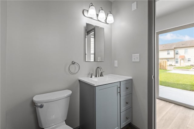 22 Mayflower St, Lincoln-Larimer, PA 15206 - half bath featuring toilet, healthy amount of natural light, vanity, and wood finished floors