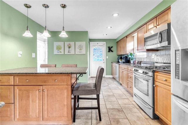 669 Carnival Dr, Plum Boro, PA 15239 - kitchen with appliances with stainless steel finishes, a breakfast bar, decorative backsplash, stone counters, and hanging light fixtures
