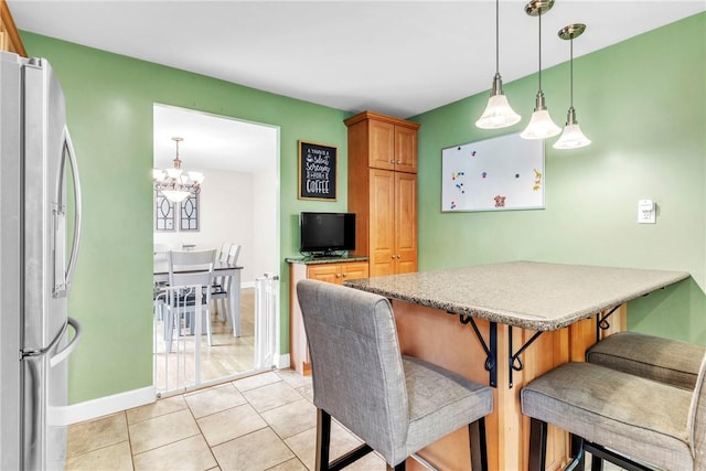 669 Carnival Dr, Plum Boro, PA 15239 - kitchen with stainless steel fridge, a chandelier, a kitchen breakfast bar, baseboards, and a peninsula