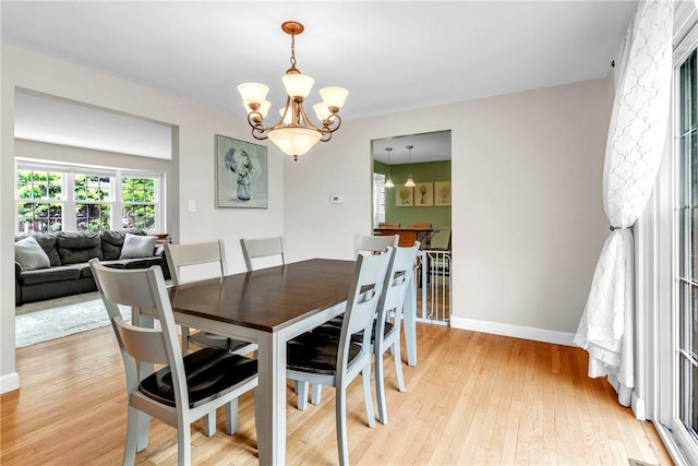 669 Carnival Dr, Plum Boro, PA 15239 - dining room with a chandelier, light wood finished floors, and baseboards