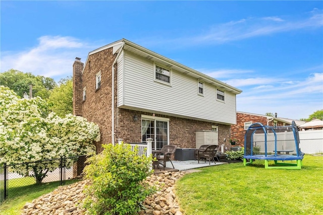 669 Carnival Dr, Plum Boro, PA 15239 - back of house with a patio area, a trampoline, brick siding, and a chimney