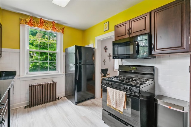 8243 High St, Mccandless, PA 15237 - kitchen with black appliances, radiator, decorative backsplash, and light wood-type flooring
