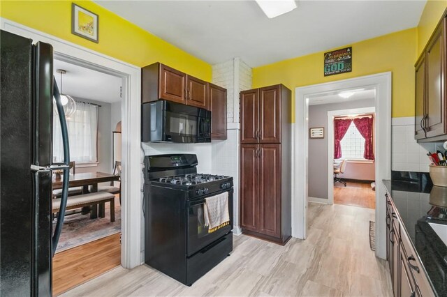 8243 High St, Mccandless, PA 15237 - kitchen with black appliances, light wood-style floors, and dark countertops