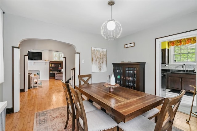 8243 High St, Mccandless, PA 15237 - dining room with arched walkways, light wood-style flooring, and a chandelier