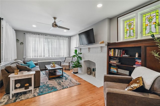 8243 High St, Mccandless, PA 15237 - living area featuring radiator, a ceiling fan, wood finished floors, a tiled fireplace, and recessed lighting