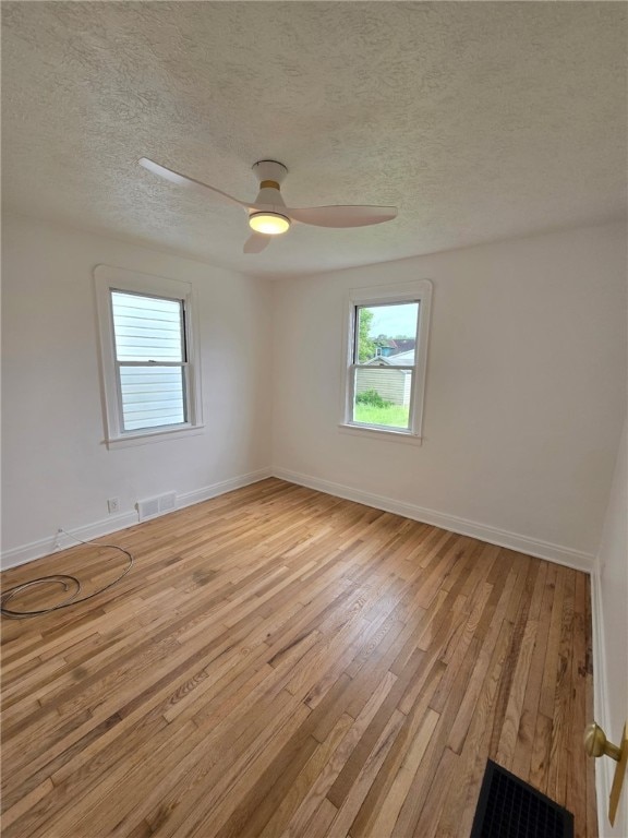 1102 Vermont Ave, White Oak, PA 15131 - empty room featuring light wood-style floors, a textured ceiling, baseboards, and a ceiling fan