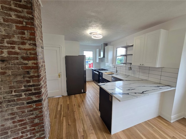 1102 Vermont Ave, White Oak, PA 15131 - kitchen featuring freestanding refrigerator, gas stove, a textured ceiling, wall chimney range hood, and light wood finished floors