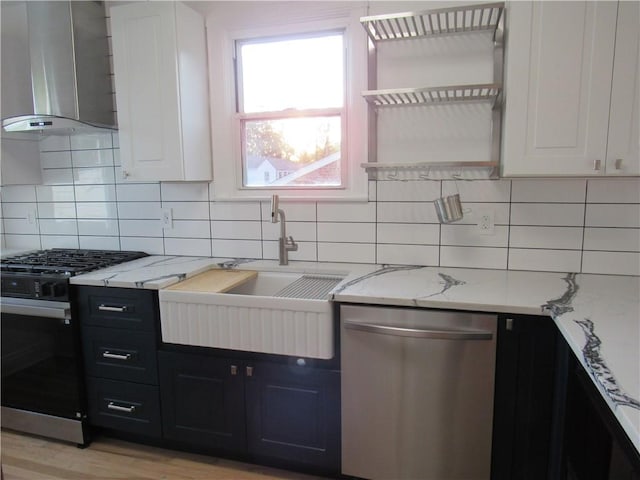 1102 Vermont Ave, White Oak, PA 15131 - kitchen with dishwasher, wall chimney range hood, range with gas stovetop, dark cabinetry, and a sink