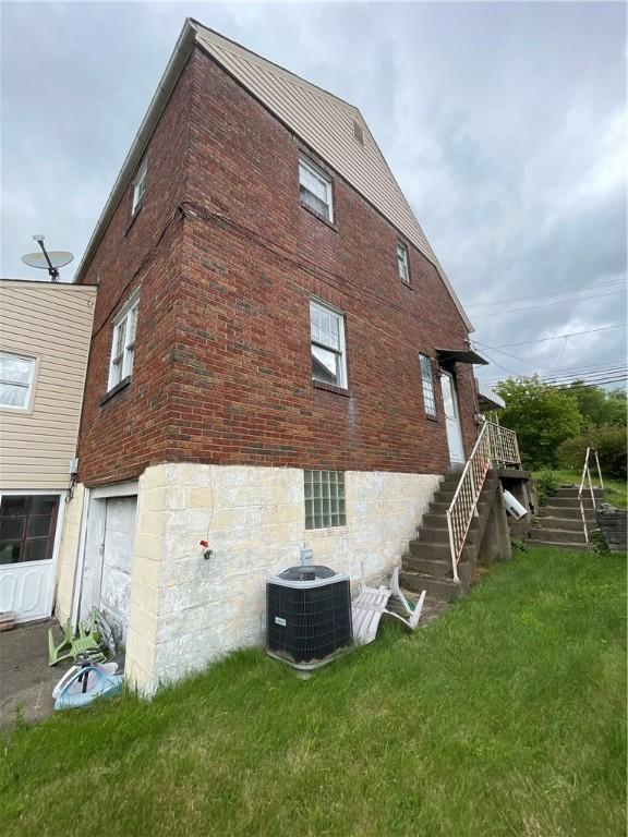 1001 Wible Run Rd, Shaler, PA 15209 - view of side of home with central air condition unit, stairway, brick siding, and a lawn