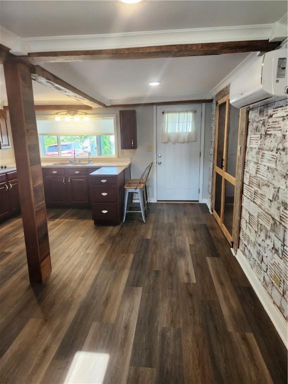 336 Fruit St, Waynsbrg/Frankln Twp, PA 15370 - kitchen featuring dark wood-style flooring, an AC wall unit, dark brown cabinetry, crown molding, and a sink