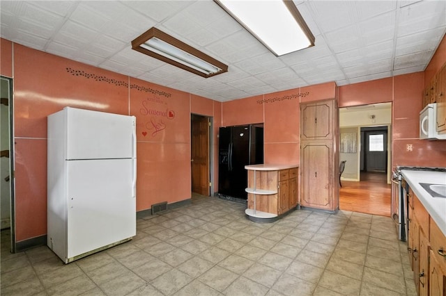 99 River Ave, Natrona, PA 15065 - kitchen with white appliances, light countertops, light floors, and brown cabinets