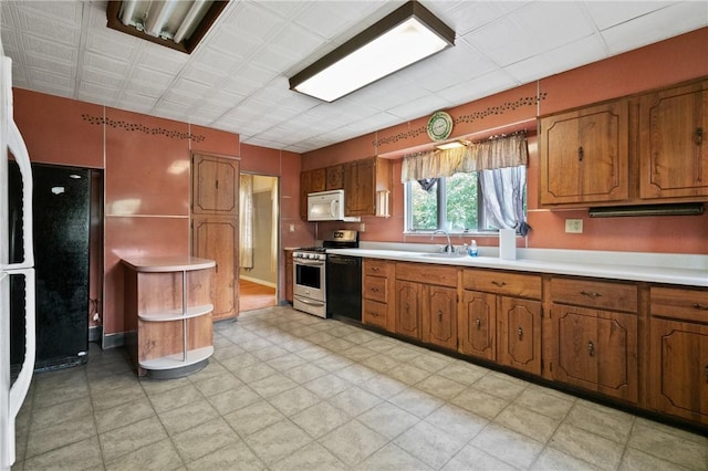 99 River Ave, Natrona, PA 15065 - kitchen with white microwave, stainless steel range with gas cooktop, brown cabinets, and light countertops