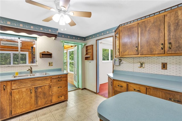 3410 E Stag Dr, West Deer, PA 15044 - kitchen with a sink, wallpapered walls, light countertops, a ceiling fan, and brown cabinets