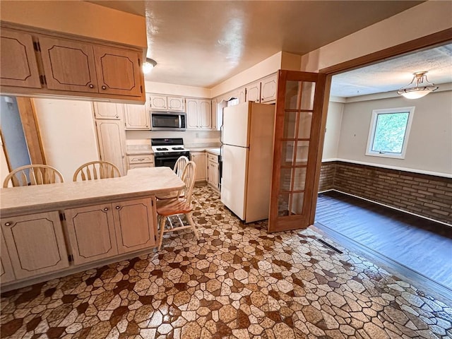 117 Harphen St, Versailles Boro, PA 15132 - kitchen with freestanding refrigerator, stainless steel microwave, gas range oven, light countertops, and french doors