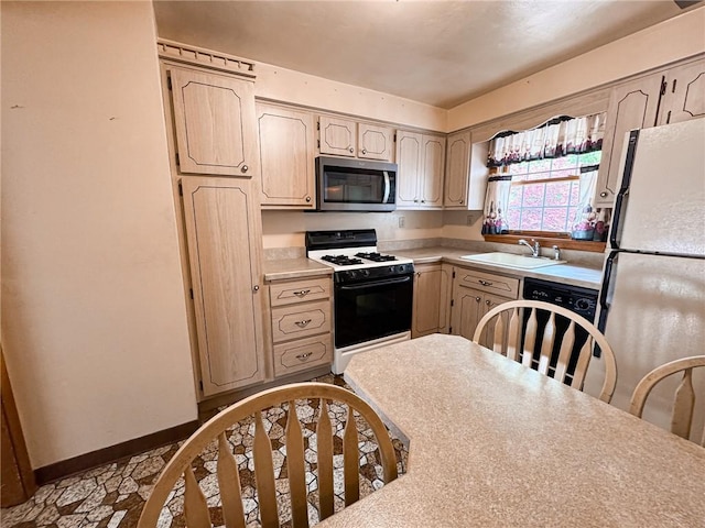 117 Harphen St, Versailles Boro, PA 15132 - kitchen with stainless steel microwave, gas range oven, freestanding refrigerator, a sink, and light countertops