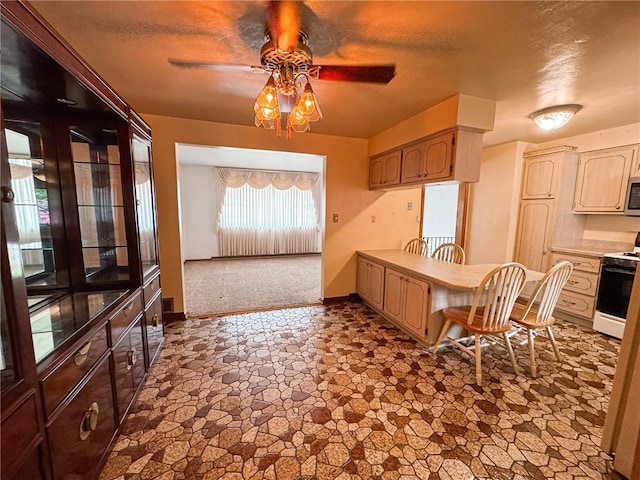 117 Harphen St, Versailles Boro, PA 15132 - kitchen featuring stove, stainless steel microwave, a ceiling fan, dark stone finish floors, and baseboards