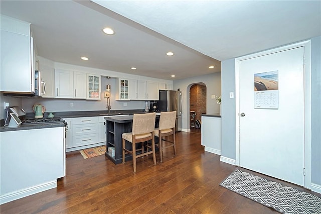 1921 Jane St, South Side, PA 15203 - kitchen featuring arched walkways, stainless steel appliances, dark countertops, a kitchen island, and dark wood-style flooring