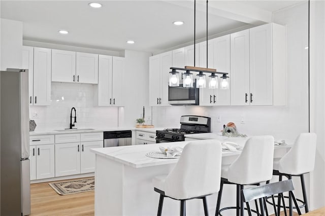 220 Dewey St, Edgewood, PA 15218 - kitchen featuring stainless steel appliances, a sink, a peninsula, white cabinetry, and recessed lighting