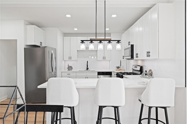 220 Dewey St, Edgewood, PA 15218 - kitchen with appliances with stainless steel finishes, a sink, a peninsula, light countertops, and white cabinetry