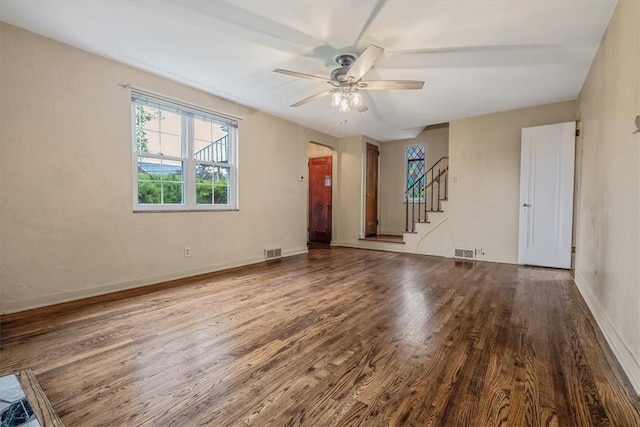 142 Slater Dr, Pleasant Hills, PA 15236 - unfurnished living room featuring wood finished floors, stairway, a ceiling fan, baseboards, and arched walkways
