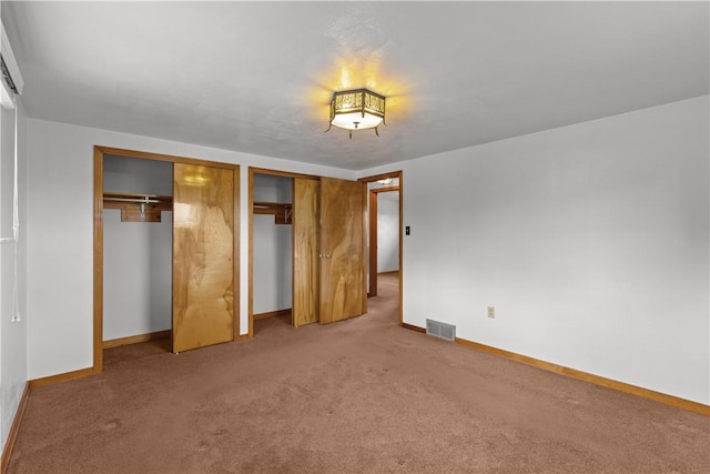 719 12th St, Pitcairn, PA 15140 - unfurnished bedroom featuring two closets, baseboards, and light colored carpet