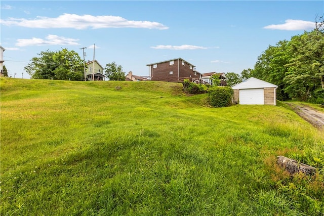 719 12th St, Pitcairn, PA 15140 - view of yard featuring an outdoor structure, a detached garage, and driveway