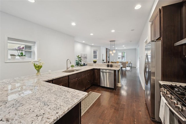 5822 Rippey St, East Liberty, PA 15206 - kitchen with a sink, appliances with stainless steel finishes, dark wood finished floors, dark brown cabinets, and light stone counters