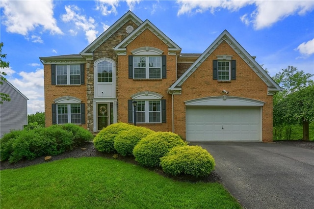 8014 Maureen Dr, Cranberry Twp, PA 16066 - colonial-style house featuring driveway, brick siding, a front yard, and a garage