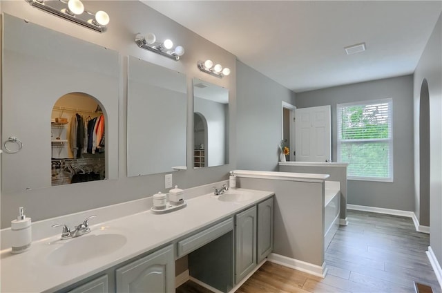 8014 Maureen Dr, Cranberry Twp, PA 16066 - bathroom with double vanity, wood finished floors, a garden tub, baseboards, and a spacious closet