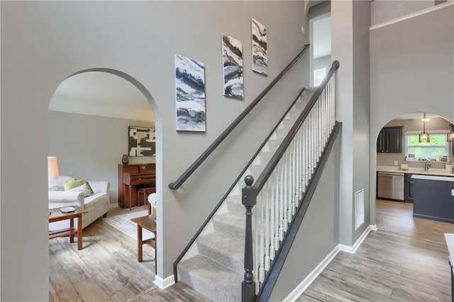 8014 Maureen Dr, Cranberry Twp, PA 16066 - staircase featuring a high ceiling, wood finished floors, arched walkways, and baseboards